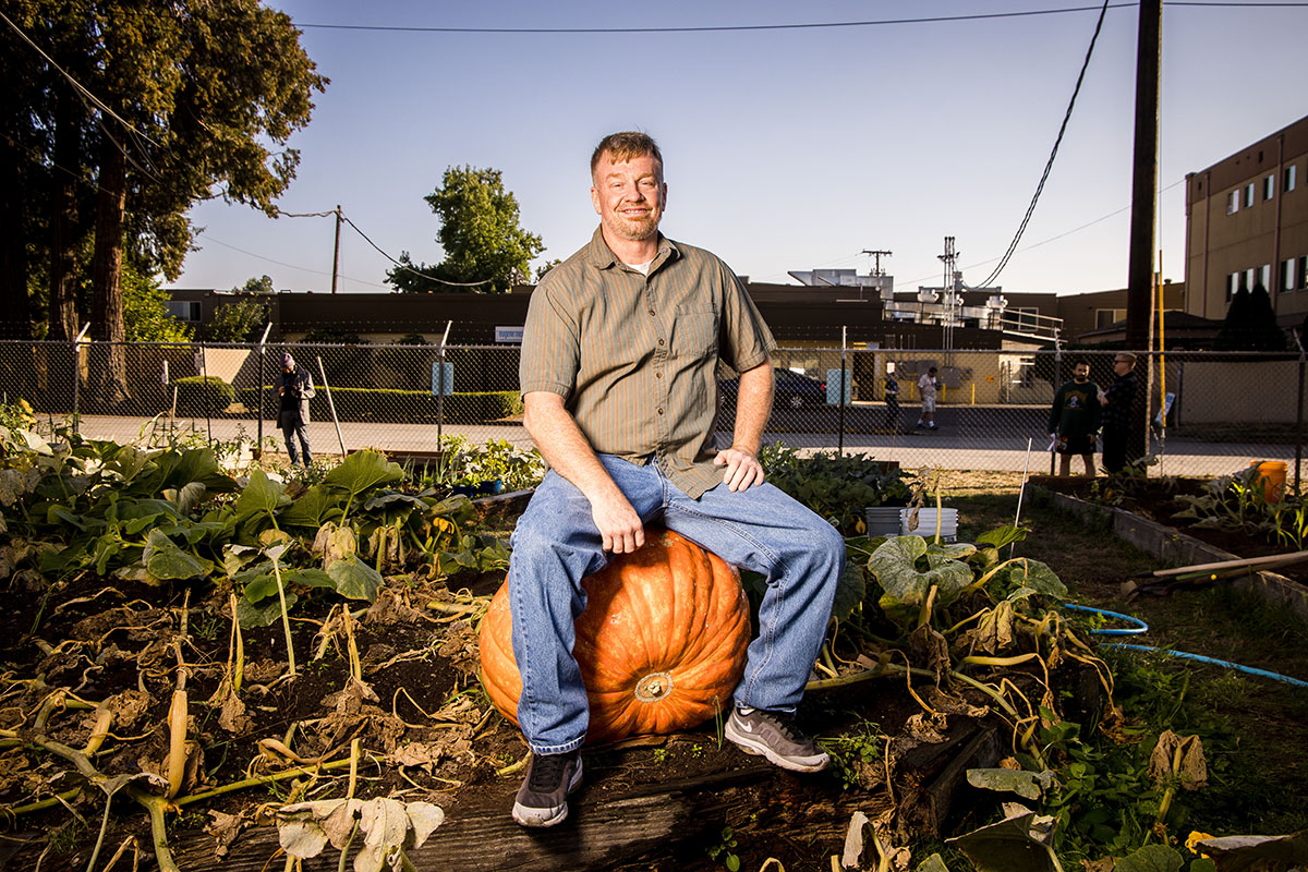 A man posing on a pumpkin